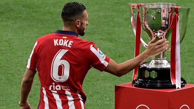 Koke touches the La Liga trophy