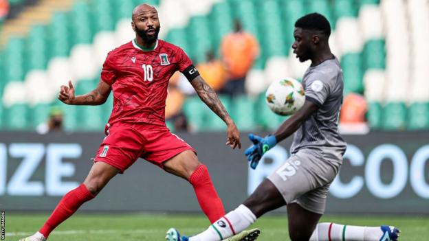 Equatorial Guinea's forward Emilio Nsue scores his team's first goal next to Guinea-Bissau's goalkeeper Ouparine Djoco during the Africa Cup of Nations 2023 Group A match with Guinea-Bissau