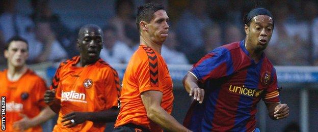 United's Lee Wilkie tackles Barcelona star Ronaldinho during their friendly at Tannadice in July 2007