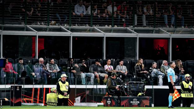 Fans watching an AC Milan match from the new pitchside seats