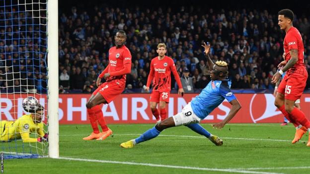Napoli's Nigerian forward Victor Osimhen (C) scores his side's second goal past Frankfurt's German goalkeeper Kevin Trapp (L) during the UEFA Champions League round of 16, second leg football match between SSC Napoli and Eintracht Frankfurt at the Diego-Maradona stadium in Naples on March 15, 2023