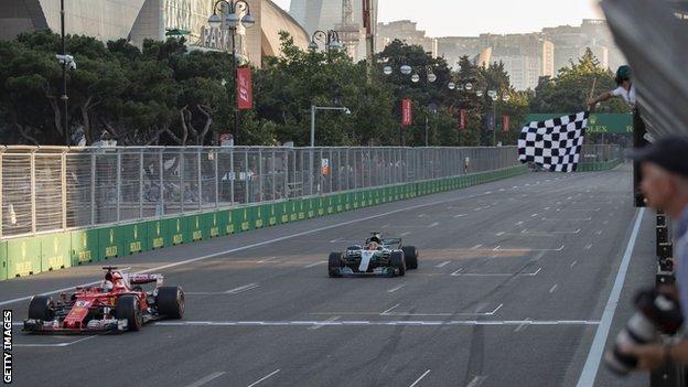 Sebastian Vettel crosses the line at the Azerbaijan Grand Prix before Lewis Hamilton