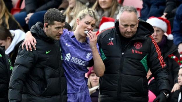 Liverpool's Gemma Bonner is helped off the pitch during the WSL match at Manchester United