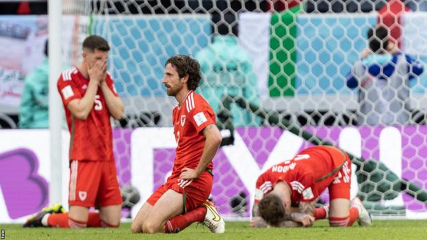 Joe Allen sinks to the turf after Wales' defeat by Iran