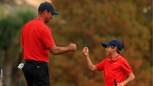 Tiger Woods (left) fist bumps his lad   Charlie (right) during the 2020 PNC Championship