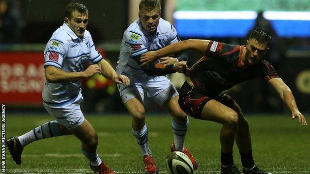 Garyn Smith and Gareth Anscombe of Cardiff Blues go for the ball with Dragons' Jared Rosser