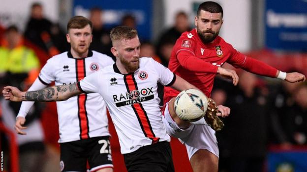 Elliot Lee (R) de Wrexham défie Oli McBurnie de Sheffield United