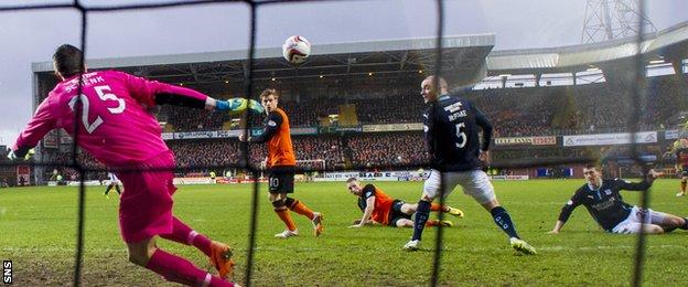 Dundee United's Chris Erskine slides in to score the opener in a 6-2 win over their city rivals on New Year's Day