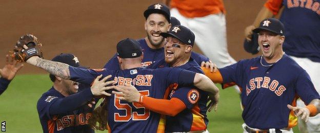 Houston Astros players engulf pitcher Ryan Pressly after they win the World Series