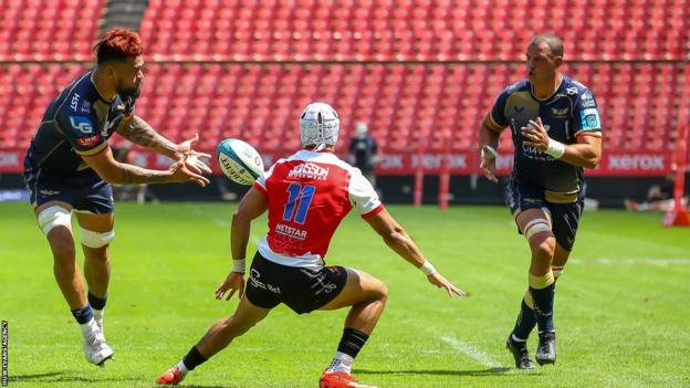 Sam Lousi of the Scarlets passes to Aaron Shingler