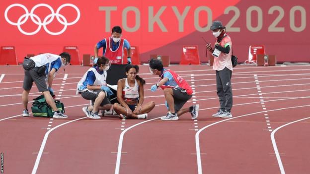 Katarina Johnson-Thompson sits on the track after sustaining an injury at the Tokyo Olympics