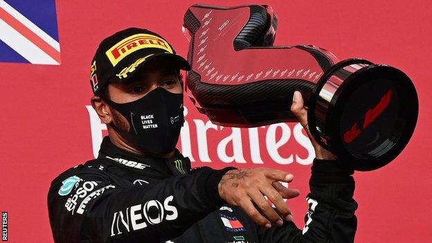 Lewis Hamilton holds up the winner's trophy