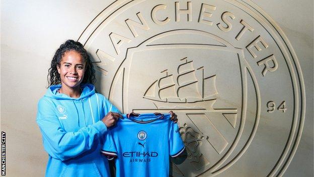 Mary Fowler holding a Manchester City shirt