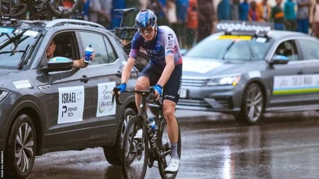 Chris Froome riding next to support car