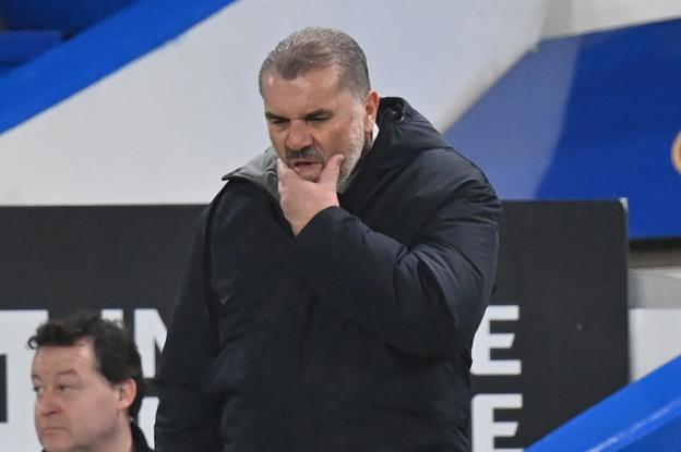 Ange Postecoglou puts his hand on his chin as he is deep in thought on the sideline