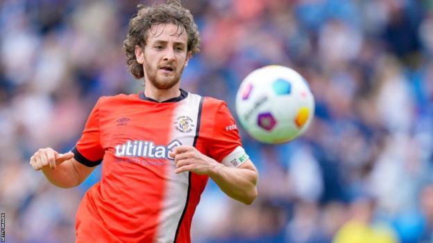 Tom Lockyer, jogador do Luton Town, reage após sofrer uma