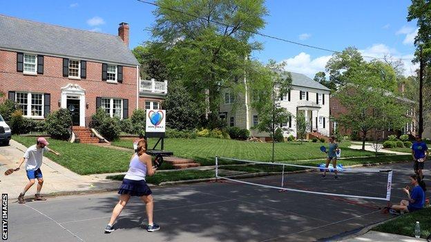 People play pickleball on a suburban street in the United States during the coronavirus pandemic