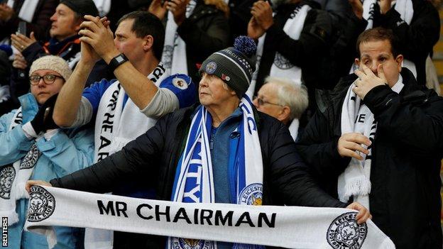 A Leicester fan holding a tribute scarf at the team's first home game since Vichai Srivaddhanaprabha's death.
