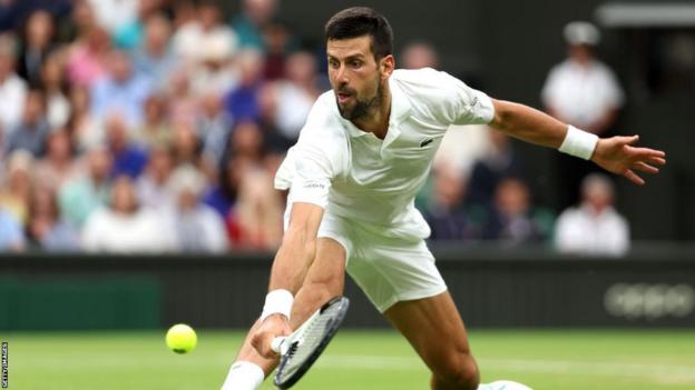 Novak Djokovic slides to scope   a shot  successful  the Wimbledon semi-finals