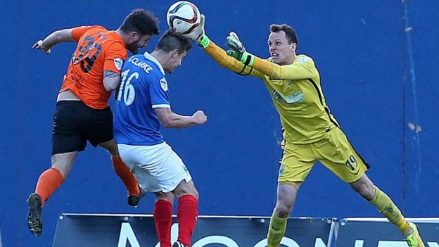 Glenn Taggart and Matthew Clarke challenge for the ball as Linfield goalkeeper Ross Glendinning attempts to clear