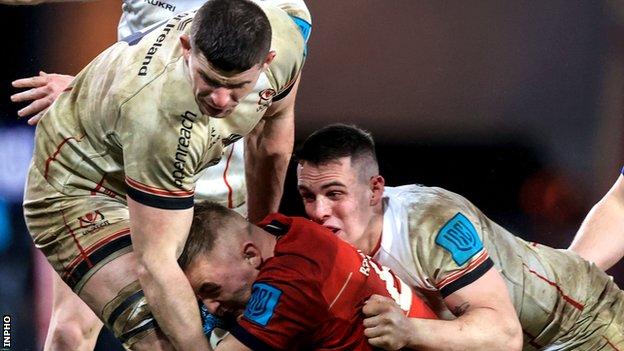 Nick Timoney and James Hume combine to tackle Munster's Gavin Coombes