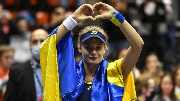 Dayana Yastremska with Ukraine's flag over her shoudlers