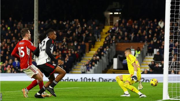 Alex Iwobi scores past Odysseas Vlachodimos for Fulham against Nottingham Forest