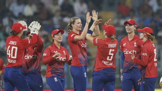 Lauren Bell and Heather Knight (middle) celebrate a wicket with the rest of the England women's side