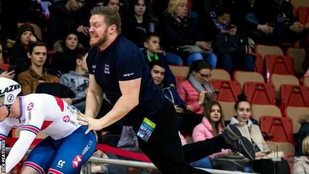 Kevin Stewart pushing off a GB cyclist at the UCI Track Cycling World Cup in Belarus in November 2019