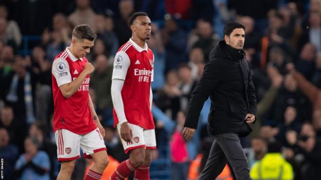 Arsenal-manager Mikel Arteta verlaat het veld met een afgewezen blik, gevolgd door Leandro Trossard en Gabriel Magalhaes