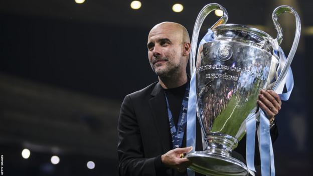 Pep Guardiola holding the UEFA Champions League trophy