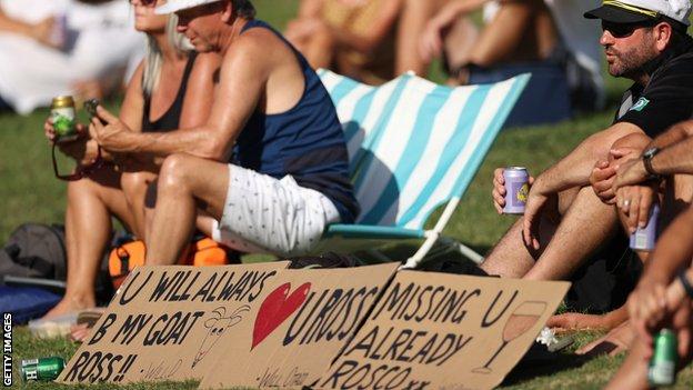 Spectators with signs supporting Taylor