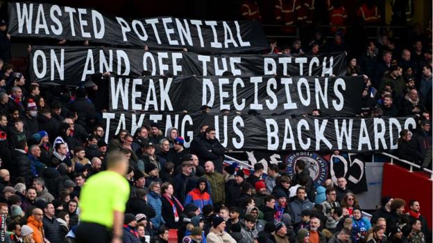 Los aficionados del Crystal Palace protestan contra la directiva del club en el reciente partido de la Premier League contra el Arsenal