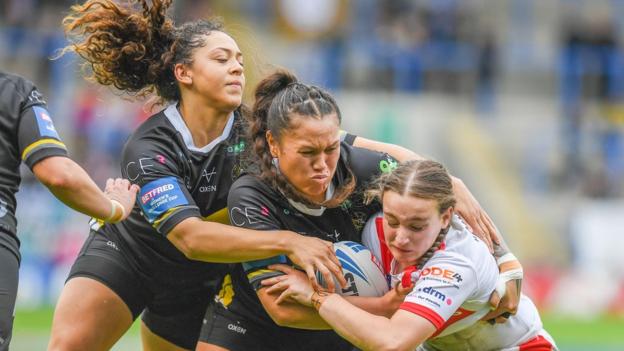 St Helens' Luci McColm (right) is tackled by York Valkyrie pair Sade Rihari and Savannah Andrade (left)