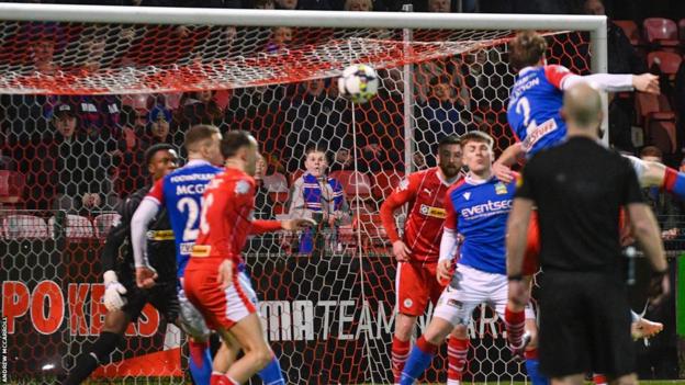 Daniel Finlayson heads home Linfield's second goal against Cliftonville