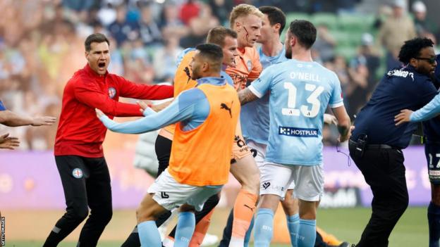 Melbourne City players are led off the field after crowd problems during their game against Melbourne Victory