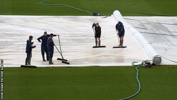 The staff at Glamorgan try and work on the pitch before the match with Surrey was abandoned