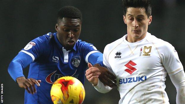 Darius Osei of Oldham Athletic (left) and George Williams of MK Dons challenge for the ball