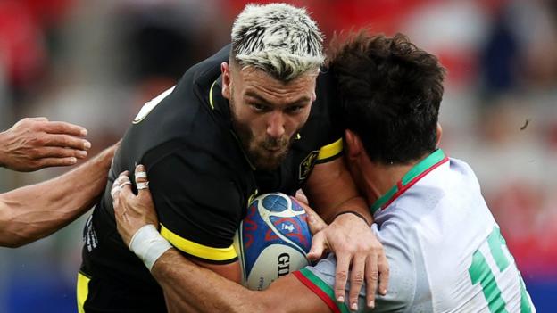 Johnny Williams of Wales is tackled by Tomas Appleton