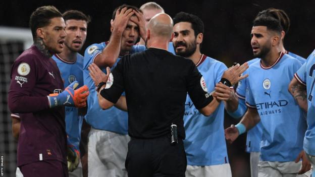 Manchester City players surround the referee