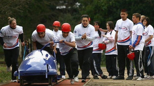 Children practice a bobsleigh start.