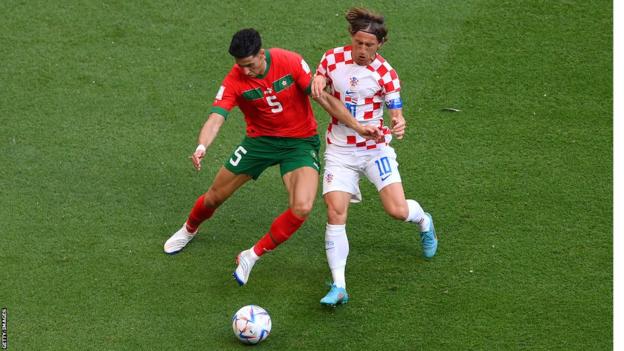 Morocco's Nayef Aguerd challenges Luka Modric of Croatia