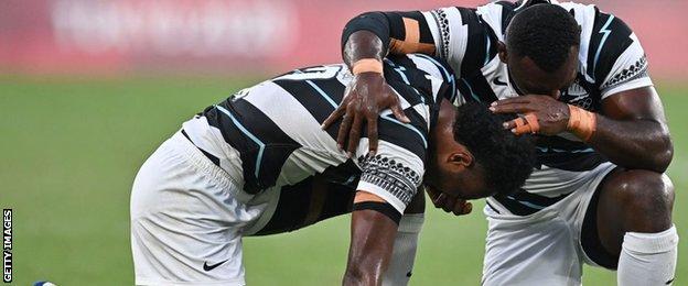 Fiji's players pray after beating New Zealand in the fina