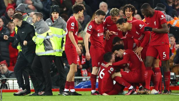 Andy Robertson is left injured after a fan collided with him while celebrating on the pitch in Liverpool's 7-0 win over rivals Manchester United