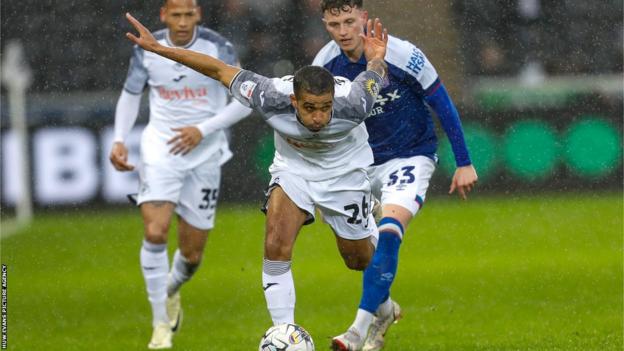 Swansea's Kyle Naughton stumbles as Ipswich goalscorer Nathan Broadhead looks on