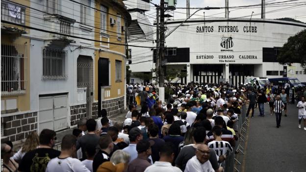 Fans queue in front of the Santos football stadium