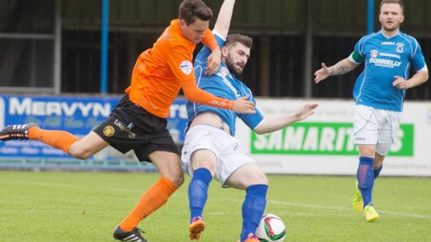 Mark Surgenor puts in a strong challenge on Dungannon's Cormac Burke during Carrick's 2-1 win