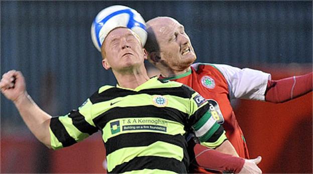 Stephen McAlorum of Donegal Celtic competes for a high ball with Cliftonville's Ryan Catney
