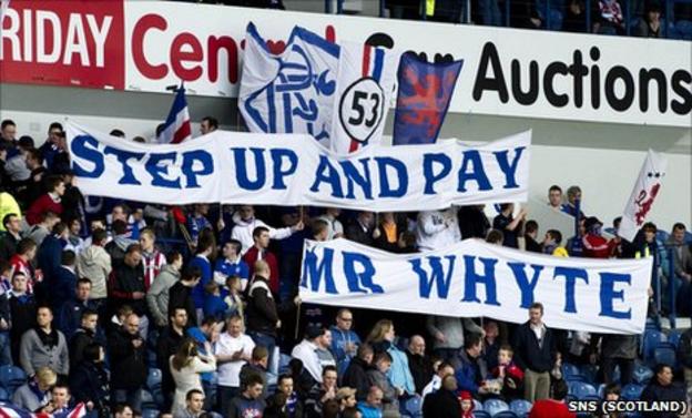 Rangers fans hold up banners which says 'Step up and pay Mr Whyte'