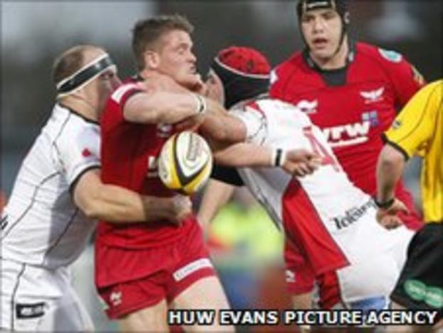 Scarlets' Tavis Knoyle is tackled during the game at Ravenhill